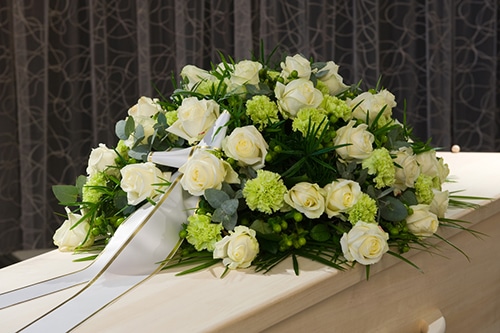 Flowers And coffin with ribbon - funeral arrangements darwin
